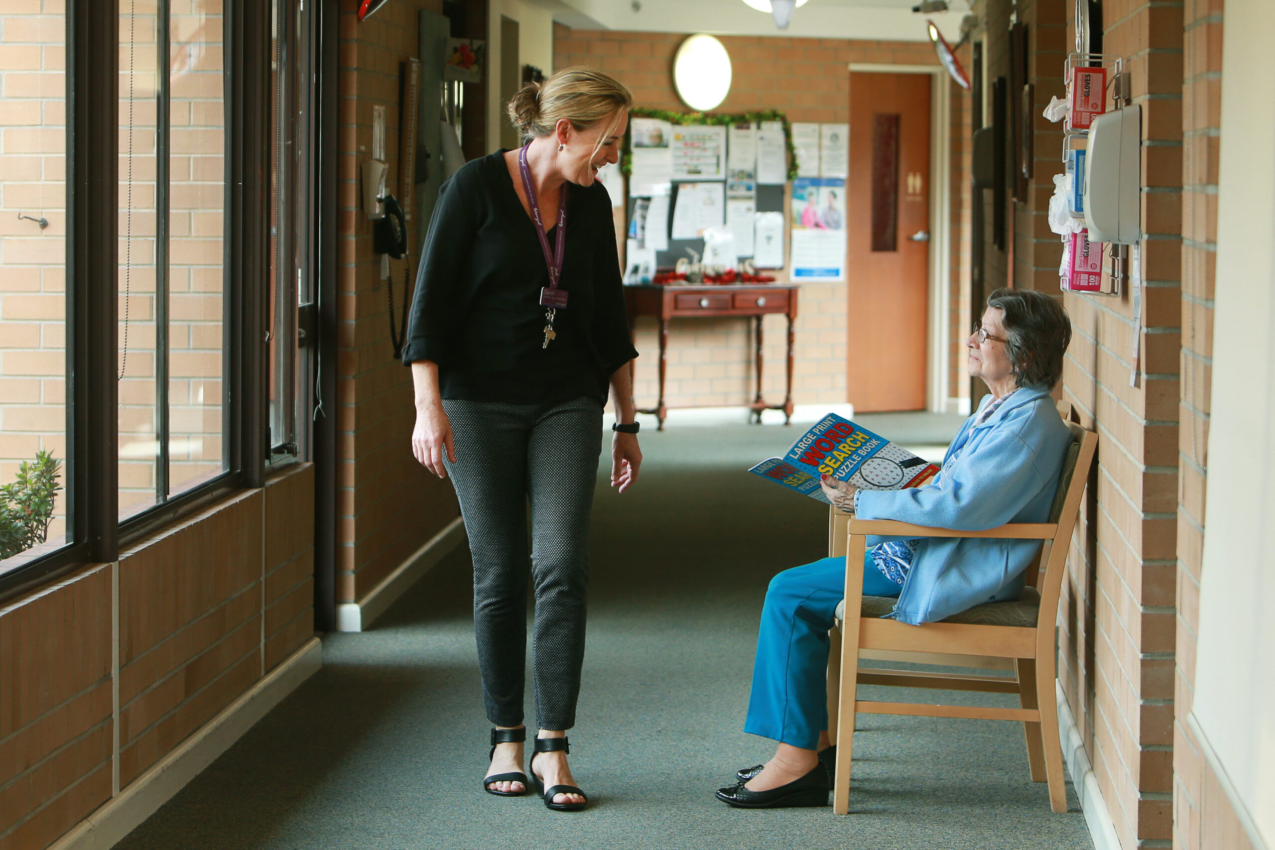 An image capturing a staff member greeting a resident with a friendly smile, showcasing the welcoming and personable atmosphere at Warrigal.