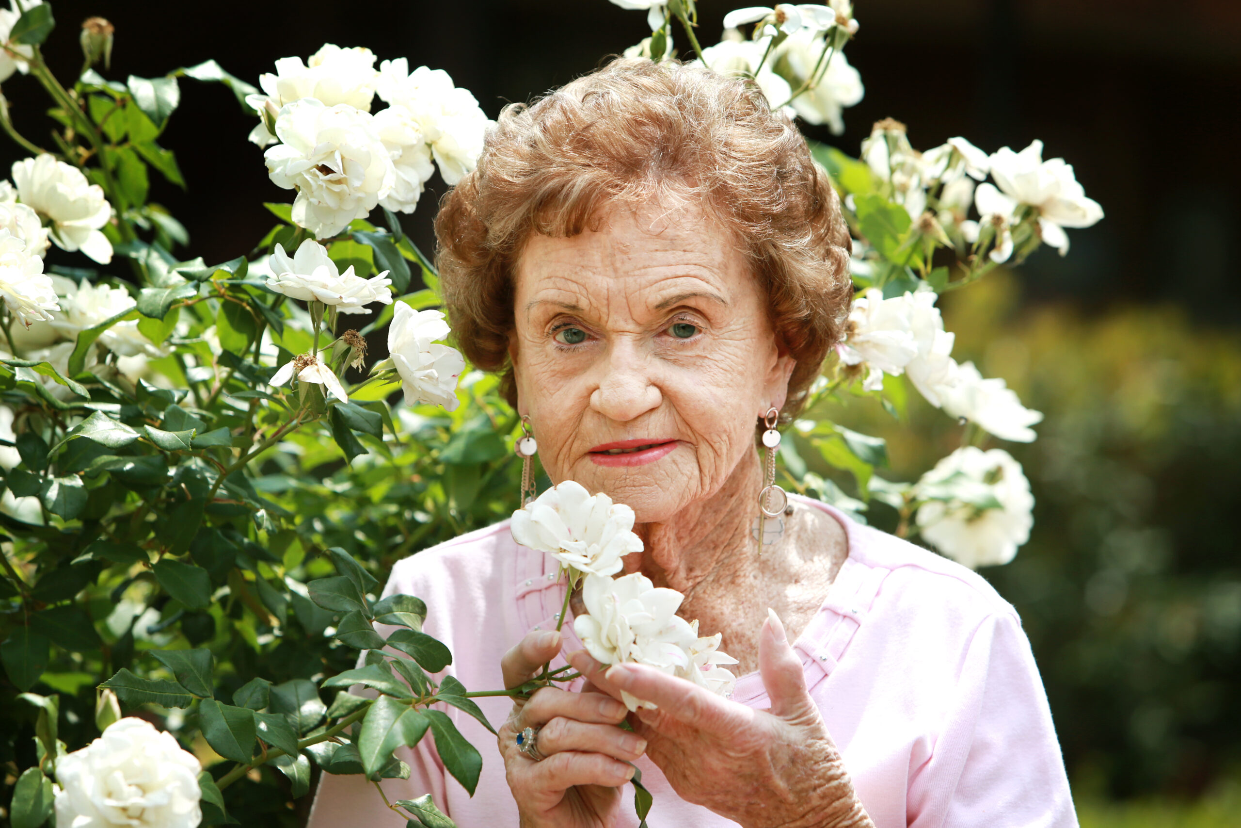 Warrigal resident surrounded by a beautiful array of flowers, enjoying a serene moment.
