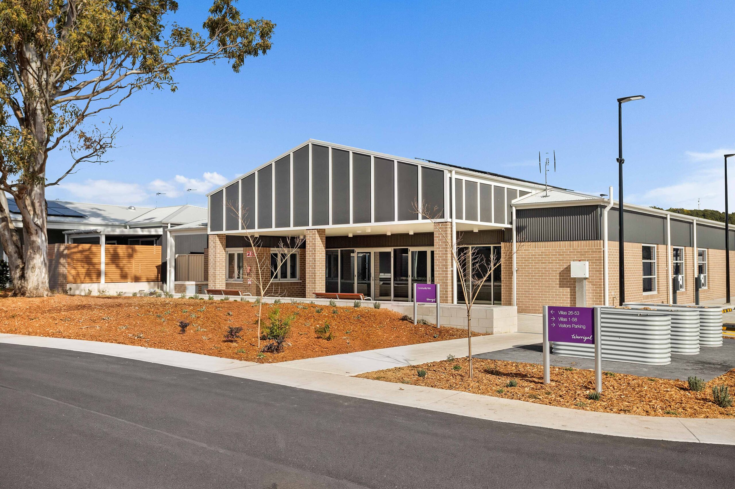 Community hub exterior shown including community garden at Warrigal Lake South community village