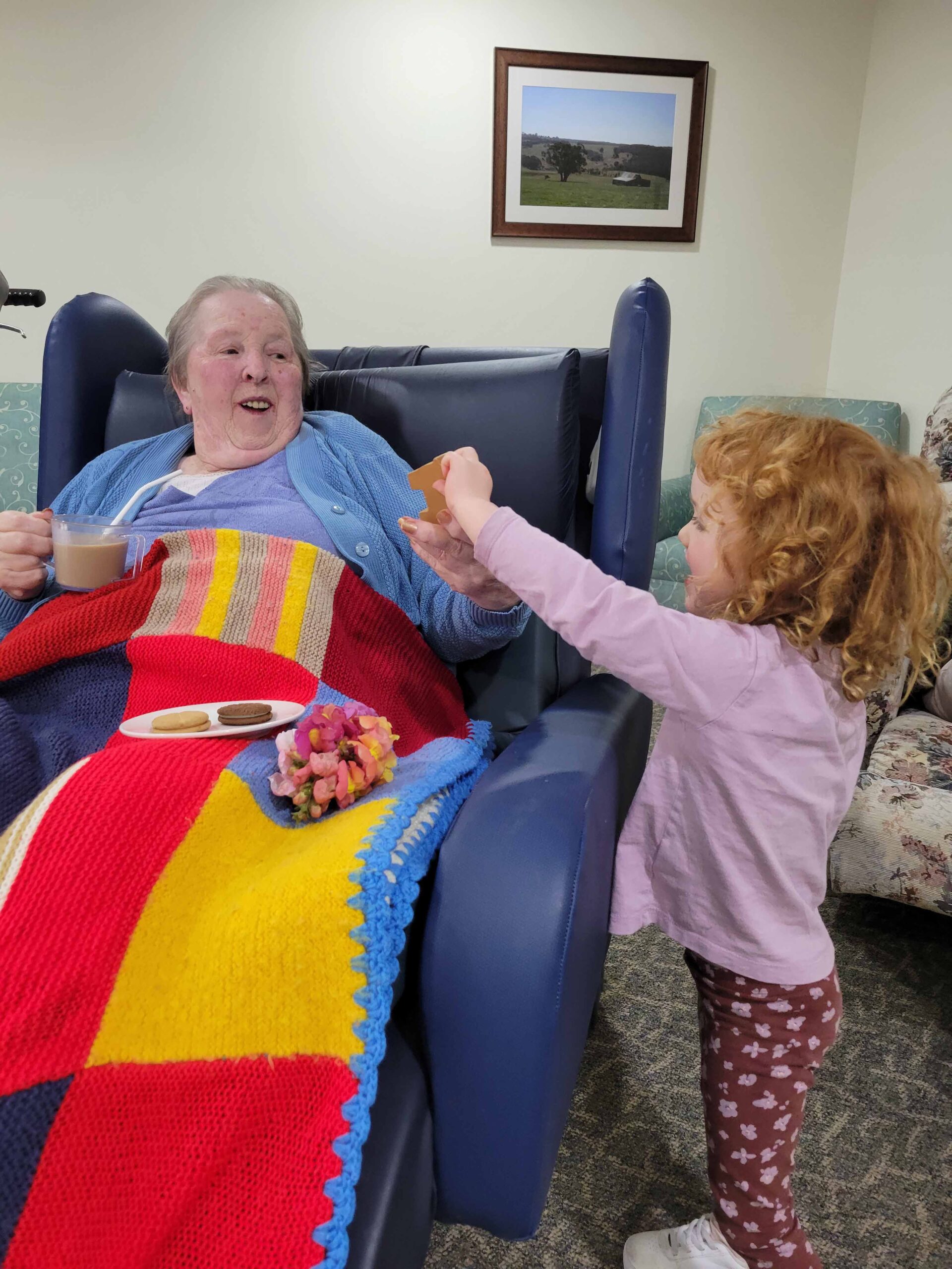 Young volunteer hands resident object